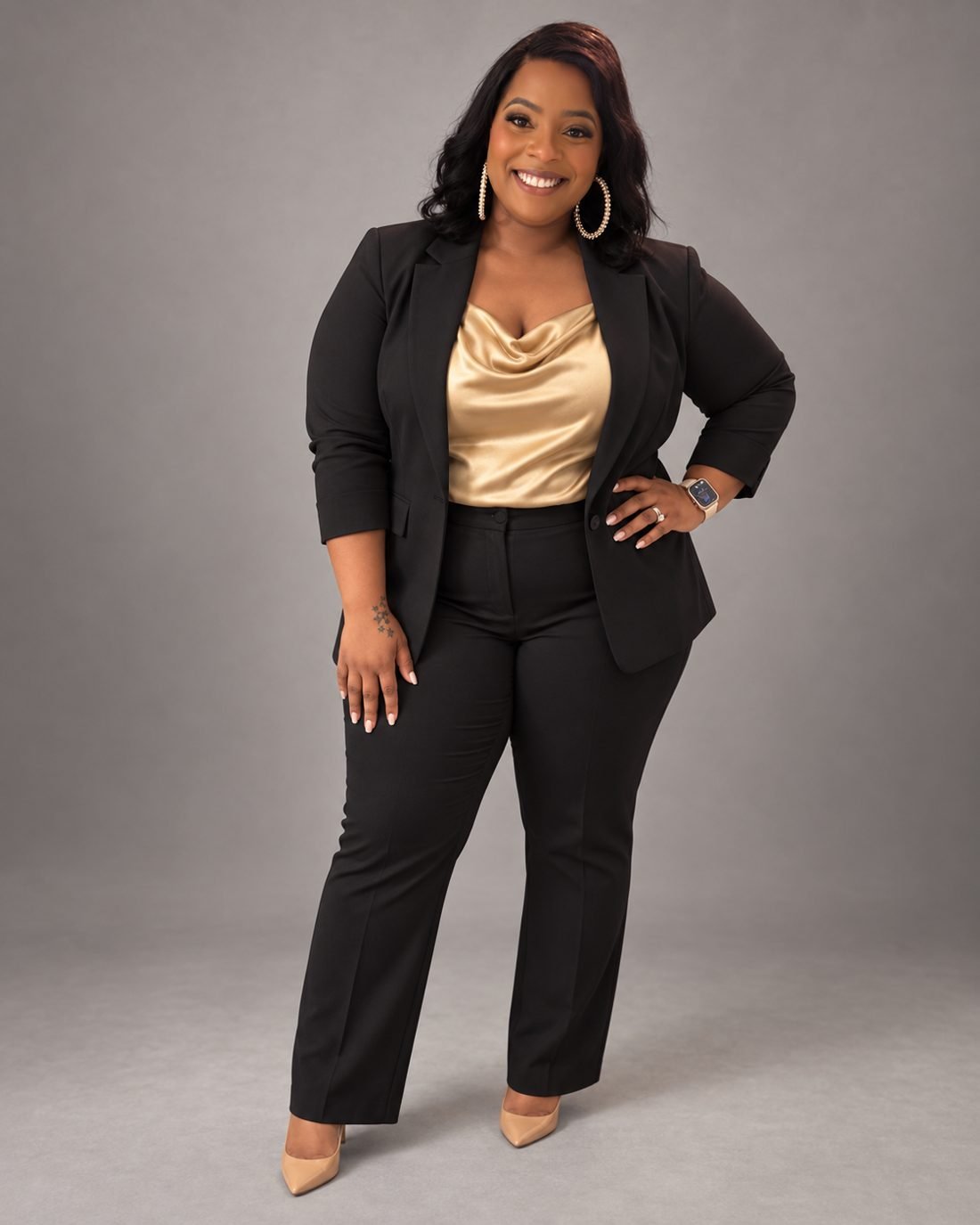 Johnnea Williams-McLeroy standing with a hand on her hip, wearing a black suit