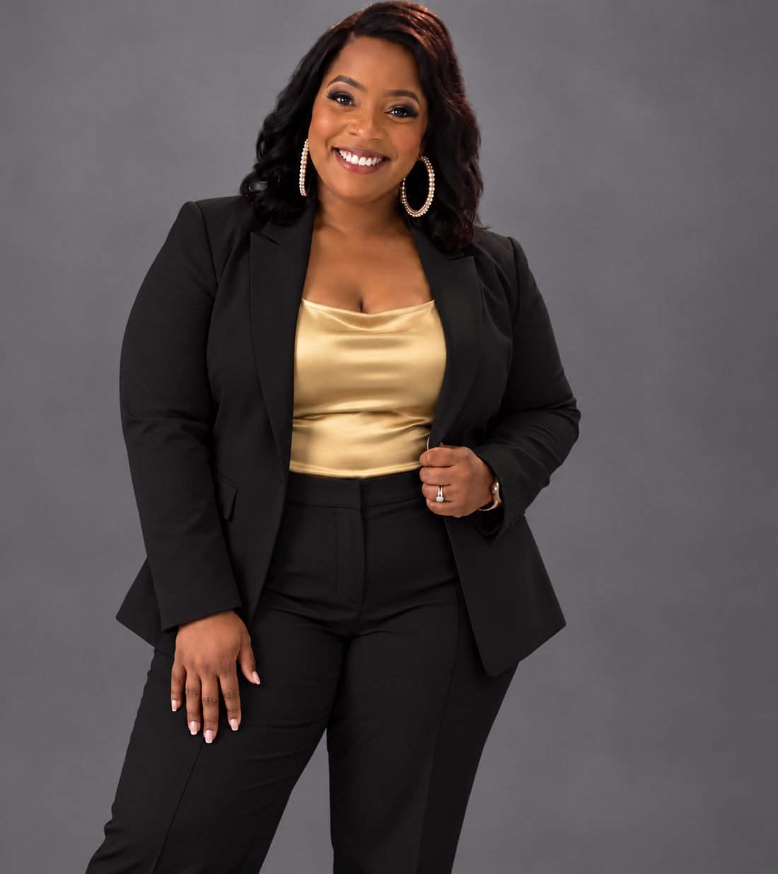 Johnnea Williams-McLeroy in a black suit and gold top, smiling